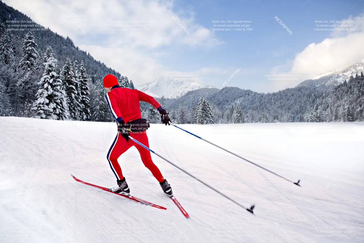 A cross-country skier dressed in a red outfit glides through pristine, snow-covered trees, with a stunning mountain backdrop. The scene captures the essence of winter sports and the natural beauty of the region.