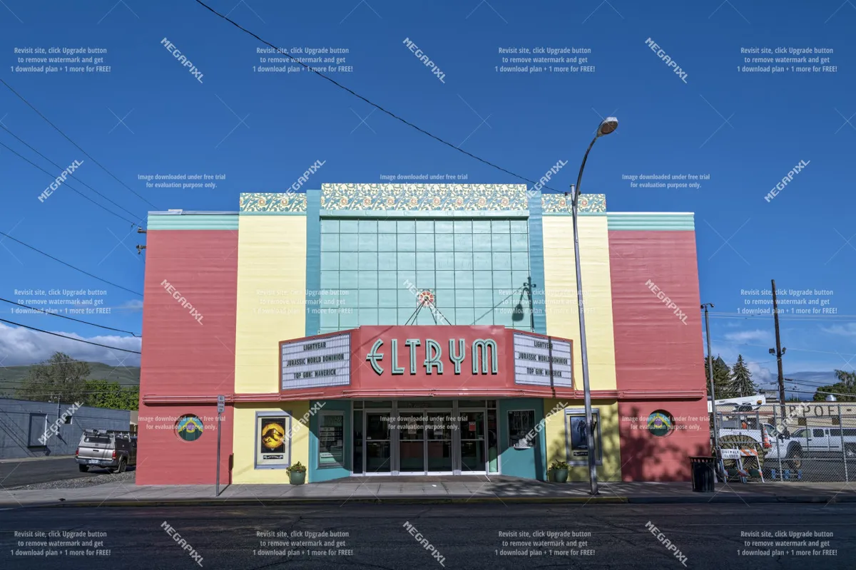 The brightly lit marquee and colorfully restored facade of a historic theater in Baker City, with decorative architectural elements and an inviting entrance that hints at vibrant arts and community events.